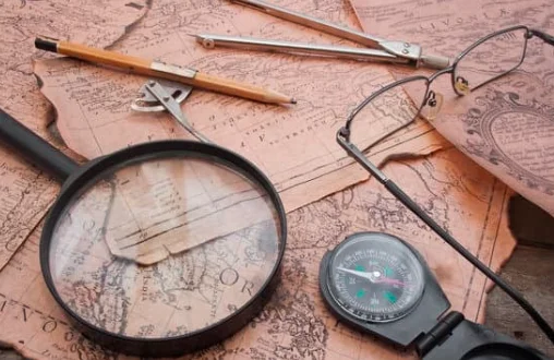 Old maps, a compass and a magnifying glass
