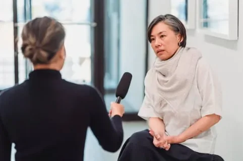 An interviewer holding a microphone during a conversation