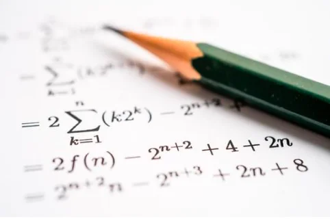 A pencil resting on mathematical expressions