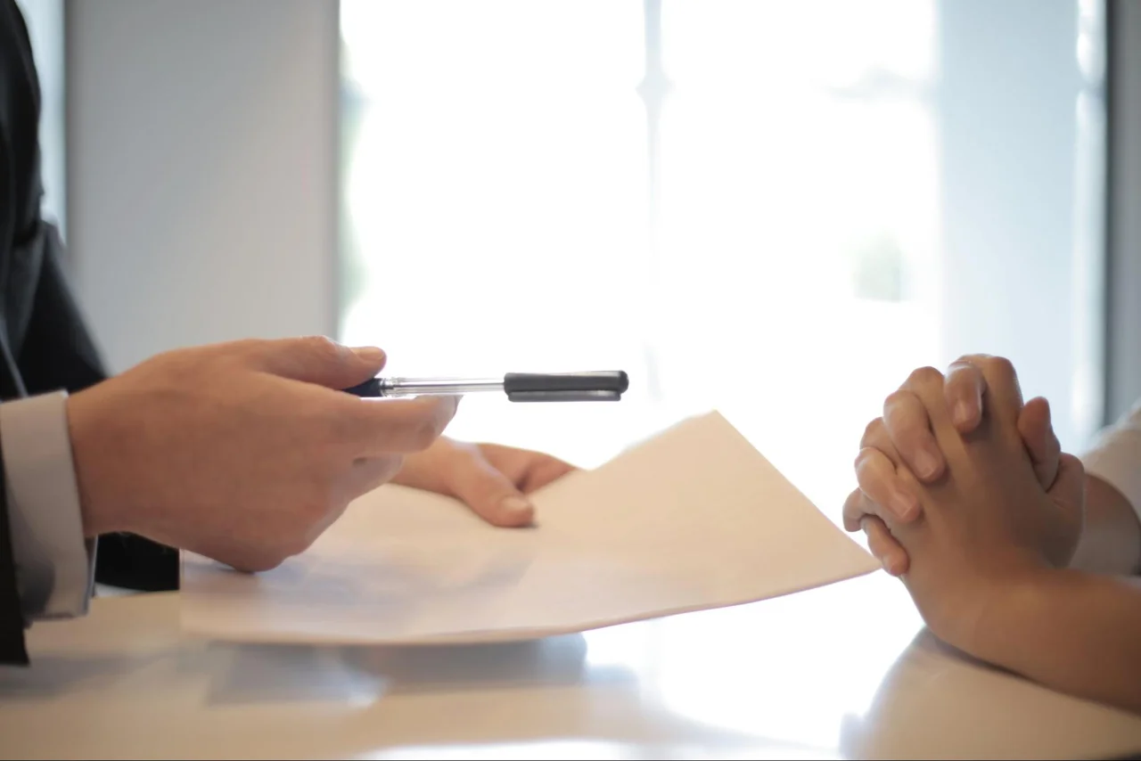 Two people discussing paperwork across a table