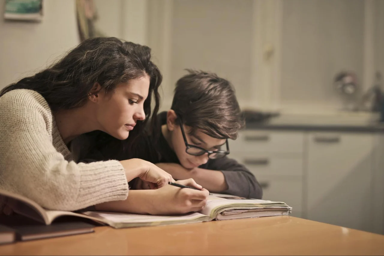 An adult helping a child with schoolwork