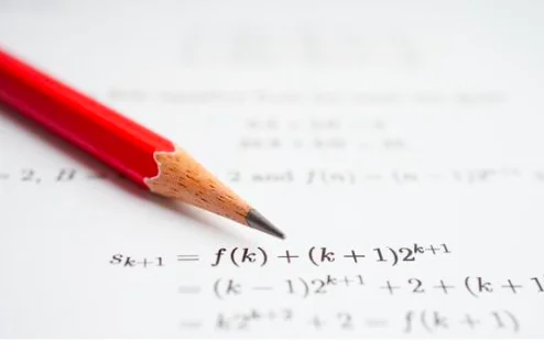 A pencil beside written mathematical expressions